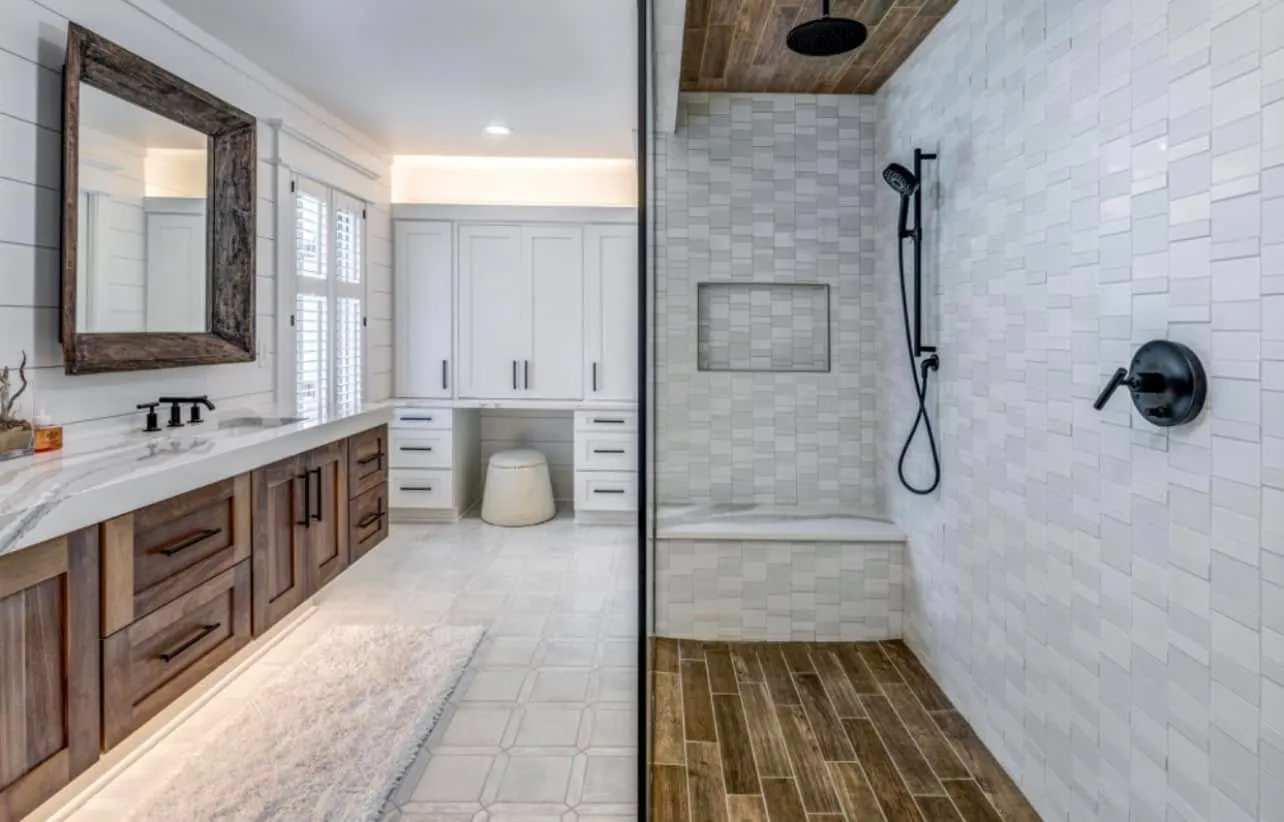 Master bath with a white-quartz-topped walnut vanity, rustic wood-framed mirror, and a walk-in shower with wood-look ceiling and black fixtures.