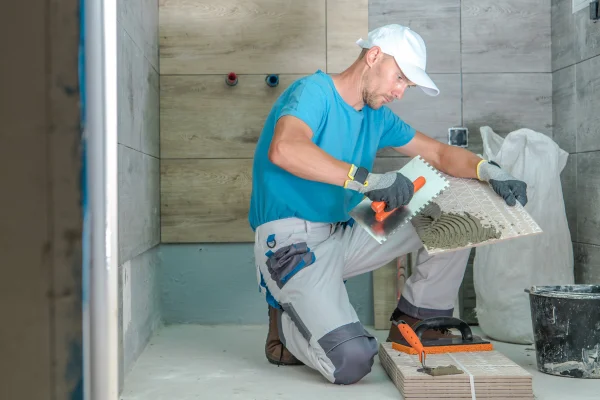 Bathroom remodeling contractor installing tiles in bathroom